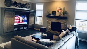 A living room with a fireplace, a television, and a sofa. - Beautiful New House in great Northern neighborhood- close to all!  (Fort Wayne)