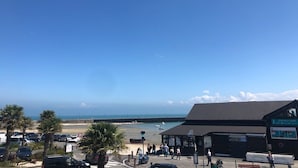 A coastal view with a beach, a parking area, and a building labeled 'Expositions.' - Le Coco de Cancale - Duplex proche mer (Cancale)