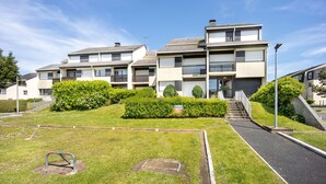 A modern apartment building with multiple balconies, a well-maintained lawn, and a clear sky. - Galene - Appt avec jardin à 700 m de la Plage (Courseulles-sur-Mer)