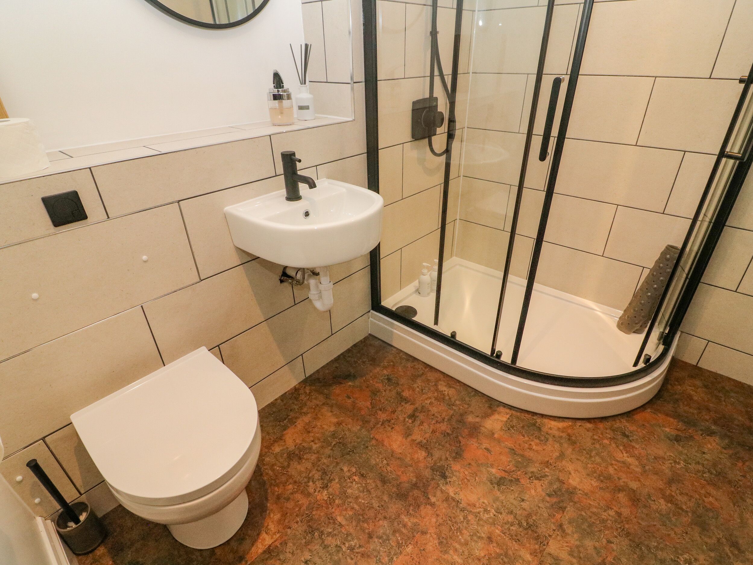 A bathroom with a toilet, sink, and glass-enclosed shower.
