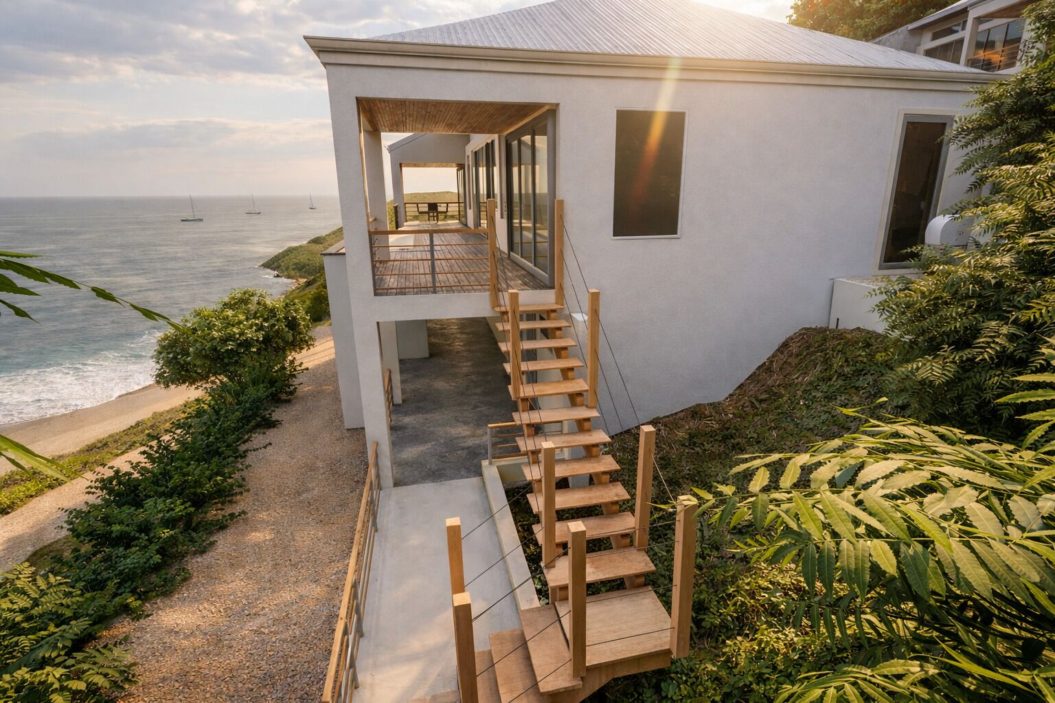 Una casa moderna con una escalera de madera que lleva a un balcón con vistas al mar.
