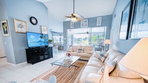 A modern living room with a sofa, coffee table, and TV. - Gorgeous Naples home with Saltwater pool in a gated community  (Naples)