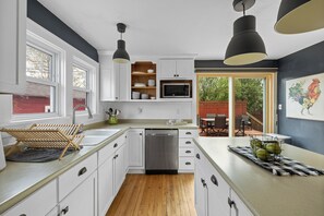 Enjoy meals in this kitchen with a large window, stainless steel appliances, and a convenient dining area with outdoor views.