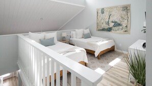 Ein geräumiges Schlafzimmer im Loft-Stil mit hohen und geneigten Decken sowie einem großen Fenster.