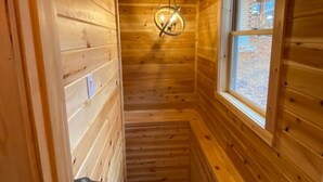A narrow wooden hallway with a window and a door at the end. - Malbec Cabin - 6 Guests - Hocking Hills - Hot Tub-Firepit-Wifi (Logan)
