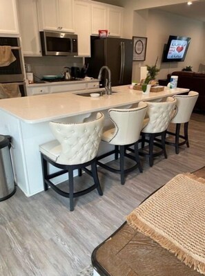Enjoy cooking in this well-equipped kitchen with a central island, stainless steel sink, and microwave.