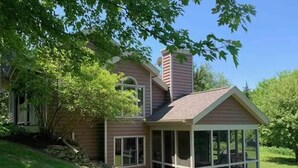 A two-story house with a large glass enclosure on the front porch. - Perfect Getaway - Cozy Cottage in The Galena Territory (Galena)