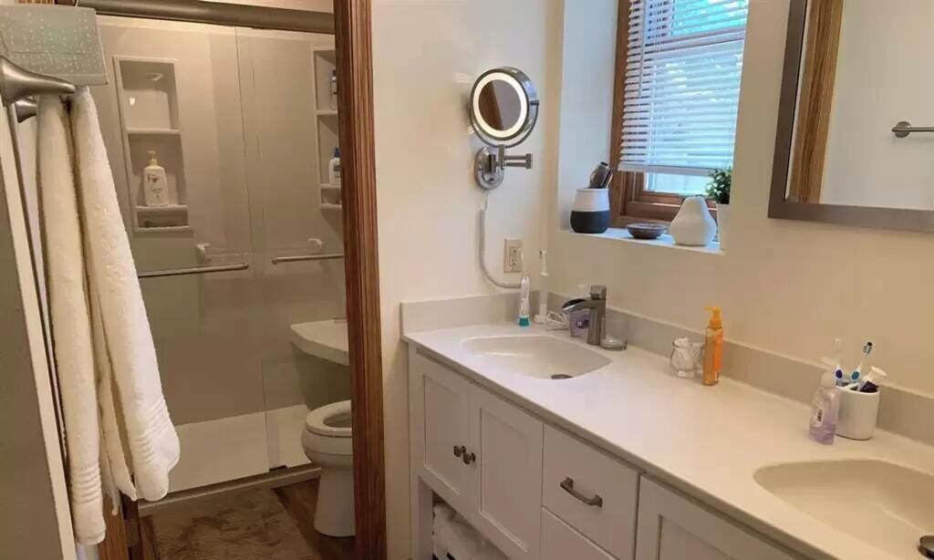 Une salle de bain avec douche, toilettes et lavabo.