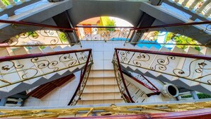 A multi-level staircase with ornate metal railings and a tiled floor.