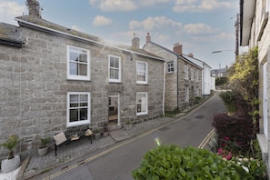 Stroll through this charming village street lined with traditional homes, featuring white-framed windows and doors.