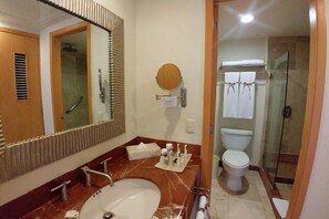 A bathroom with a sink, mirror, towel rack, toilet, and shower. - Lively Caribbean Studio with Beach & Pool (San Miguel de Cozumel)