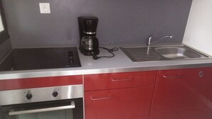 Une cuisine équipée d’un four encastré, d’une machine à café et d’un évier.