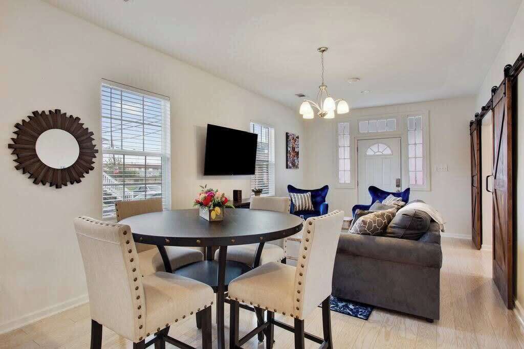 A dining area with a round table, chairs, and a TV on the wall.