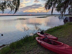 A calm lake at sunset with two red kayaks docked on the shore. - Lake front cottage (Salt Springs)