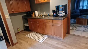 A kitchen with wooden cabinets, a countertop, and a built-in oven. - Cozy Cottage (Ashville)