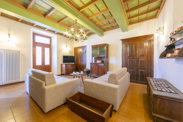 A living room with two sofas, a wooden coffee table, a TV, and a fireplace.