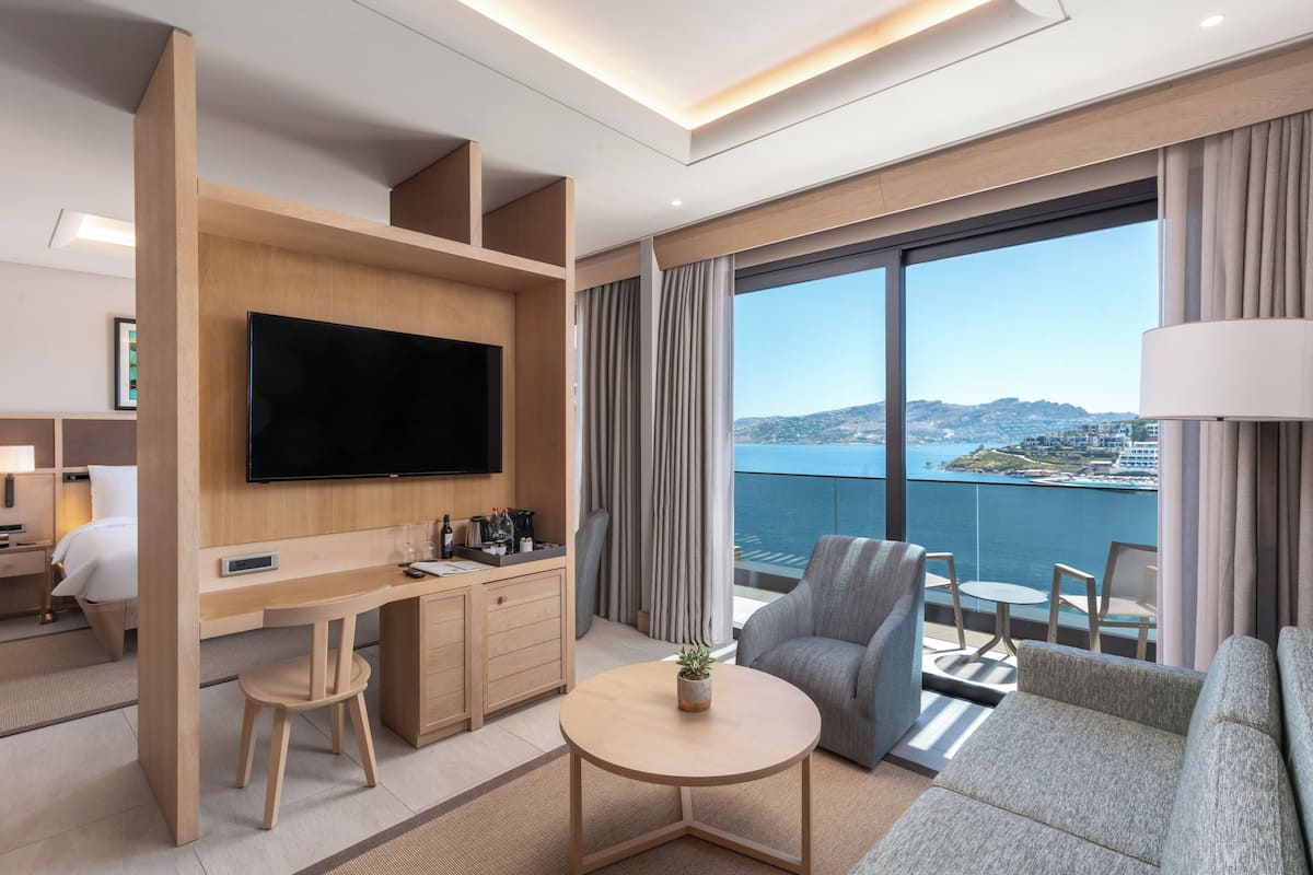 Suite junior, 1 cama King size, vista al mar | Ropa de cama de alta calidad, edredón y minibar