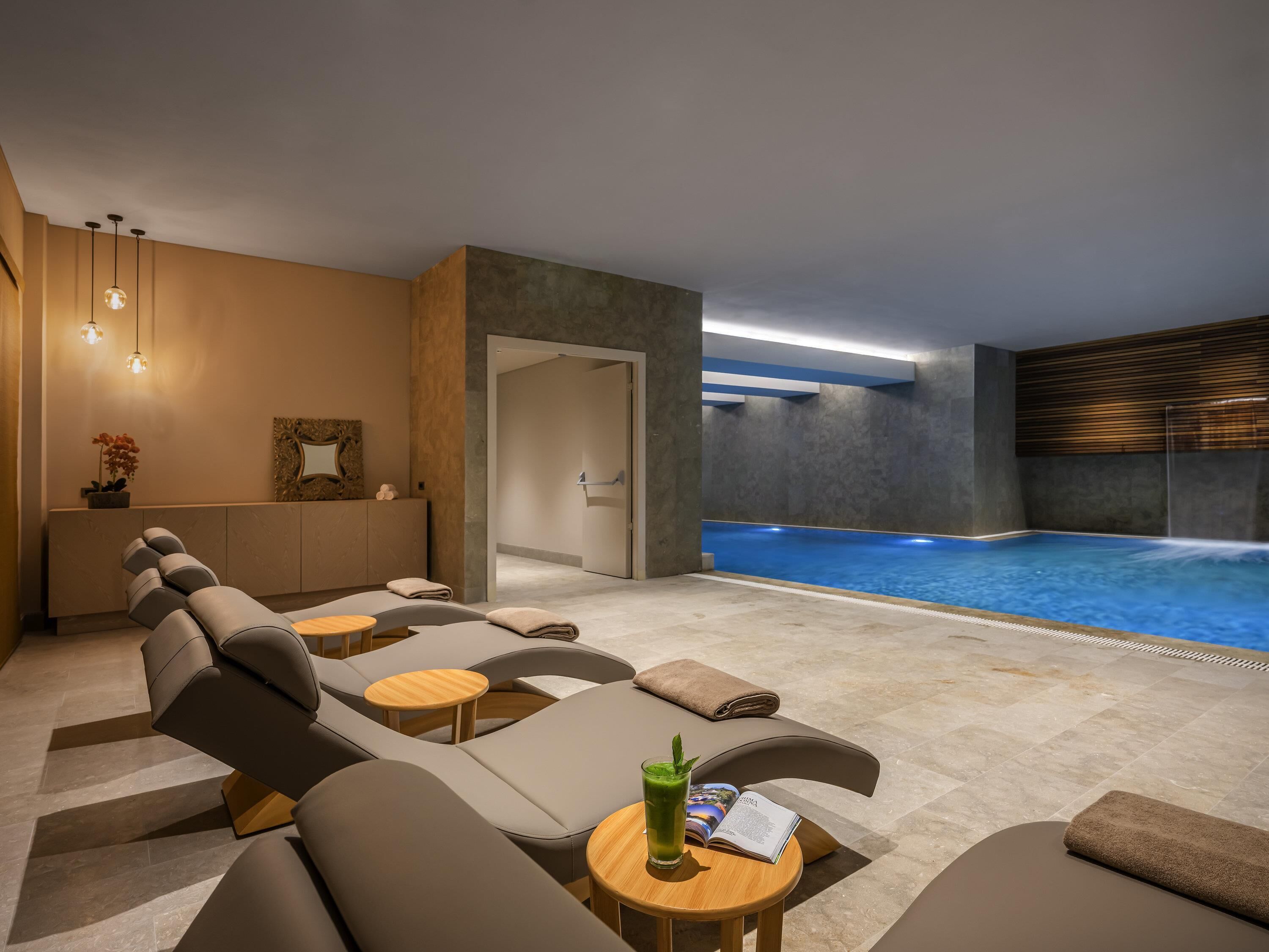 Una piscina techada, una piscina al aire libre de temporada, sombrillas