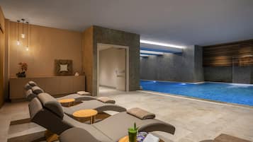 Una piscina techada, una piscina al aire libre de temporada, sombrillas