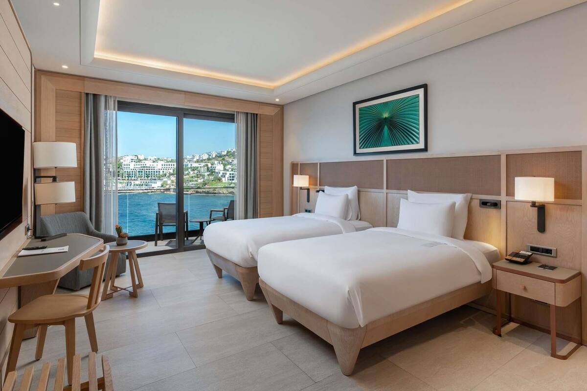 Chambre Deluxe avec lits jumeaux, 2 lits une place, vue mer | Literie de qualité supérieure, couette en duvet d'oie, minibar