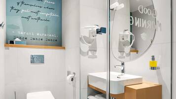 A modern bathroom with a toilet, bidet, and a mirror with a quote.