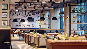 Un interior moderno con zonas de estar, mesas y plantas decorativas.
