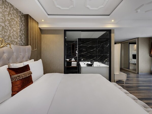 A modern hotel room with a large bed, a bathroom with a marble sink, and a walk-in closet. - Mövenpick Hotel Trabzon (Trabzon)