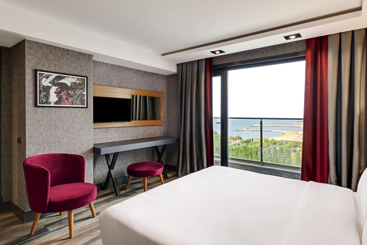 Suite junior, varias camas, vistas parciales al mar | Minibar, caja fuerte, escritorio y sistema de insonorización