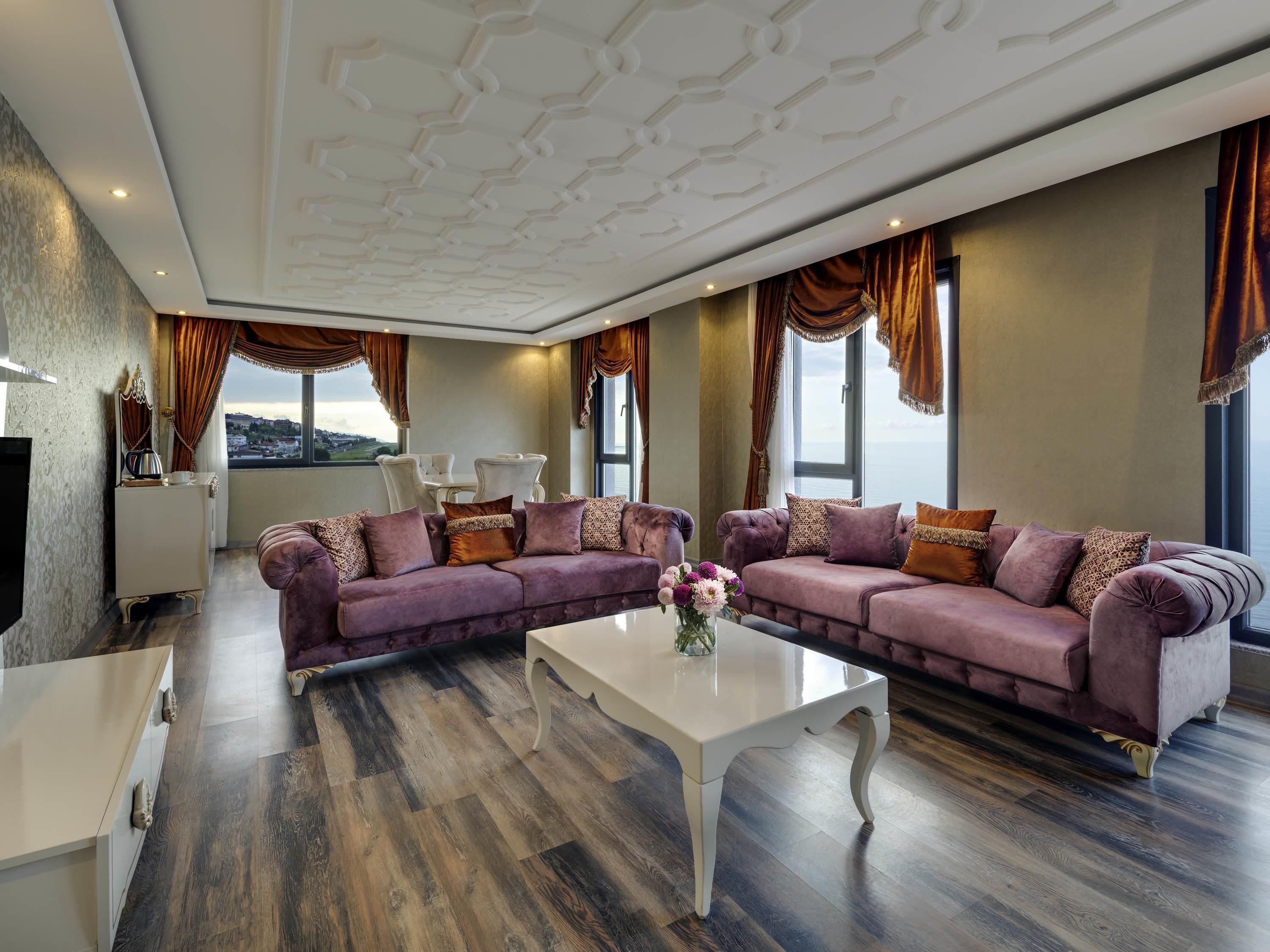 Una sala de estar moderna con dos sofás, una mesa de centro y vistas a un paisaje urbano.