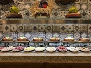 Exposição de comida com vários pratos e uma decoração de vasos.