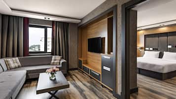 Suite júnior, diversos llits, vistes parcials al mar | Minibar, caixa forta a l'habitació i escriptori