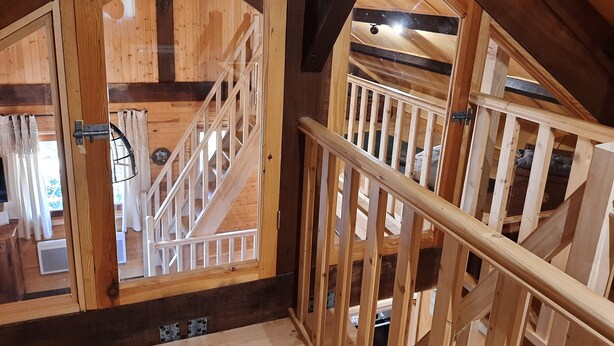 Un intérieur en bois avec un escalier et une porte donnant sur une autre pièce.