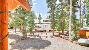 Un terrain de camping équipé de emplacements pour camping-cars, de tables de pique-nique et d’un chalet en bois.