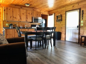 L’intérieur d’un chalet en bois comprend un coin repas, une cuisine et un espace salon confortable.