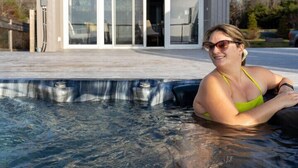 Un bâtiment moderne doté de grandes portes vitrées et d’une piscine à l’avant.