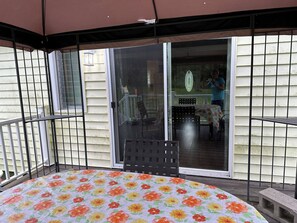 A covered patio with a table and chairs, a sliding glass door leading to a backyard, and a house with siding. - Catskill Mountain House private 5 acre backyard,
Golf, Ski, Hike, Boating, Fish (Freehold)
