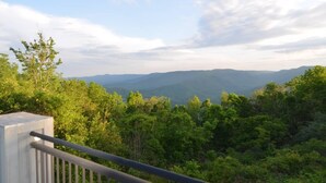 Een balkon met uitzicht op een bebost berglandschap.