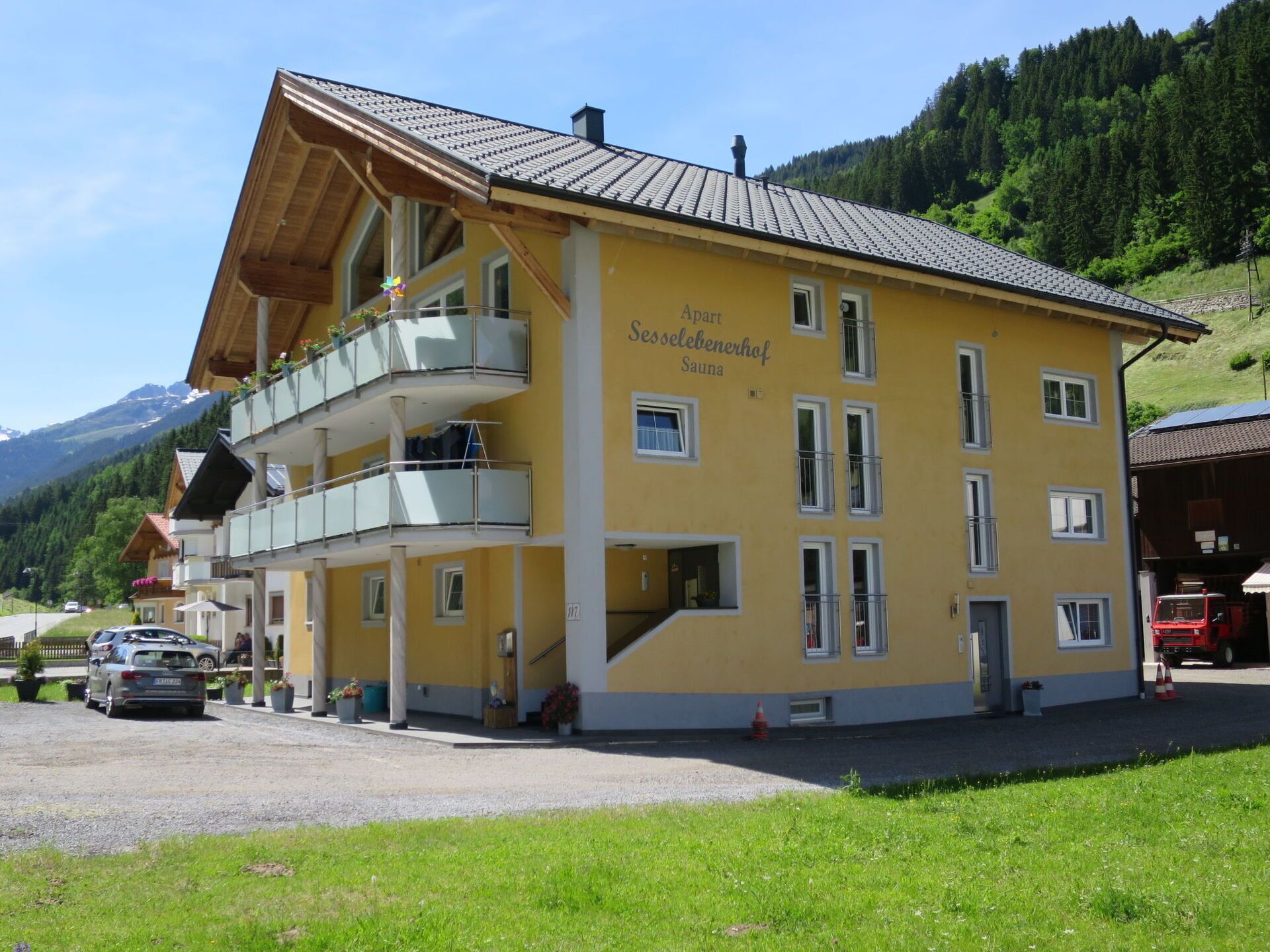 A yellow building with balconies and a sign reading "Sesseleibnerhof Sauna".