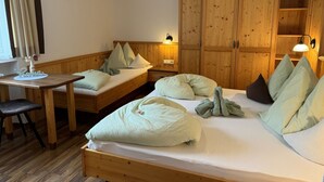 Une pièce chaleureuse avec un lit en bois, un banc, une petite table et une armoire.