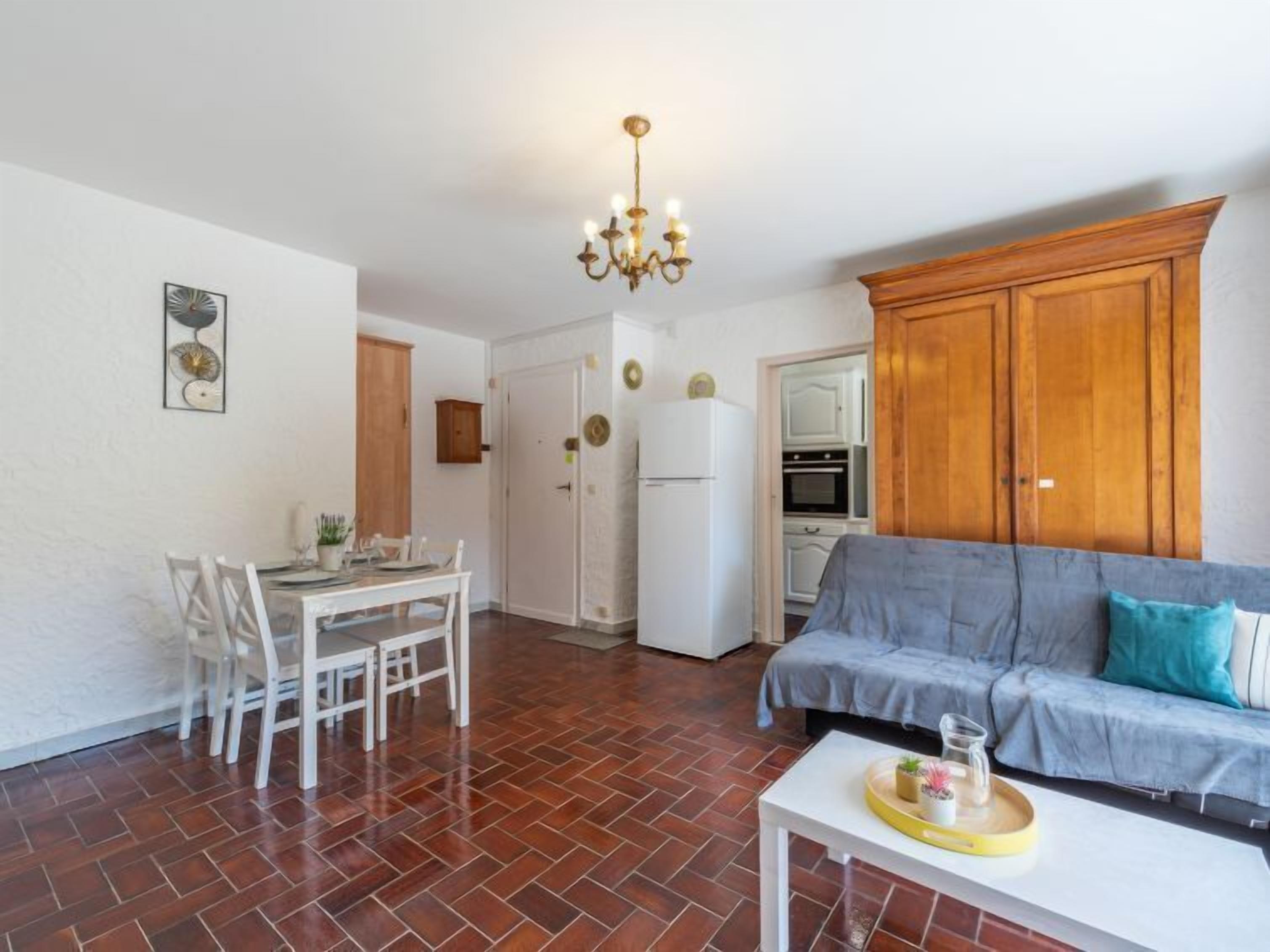 A compact living space with a dining area, kitchenette, and a sofa.