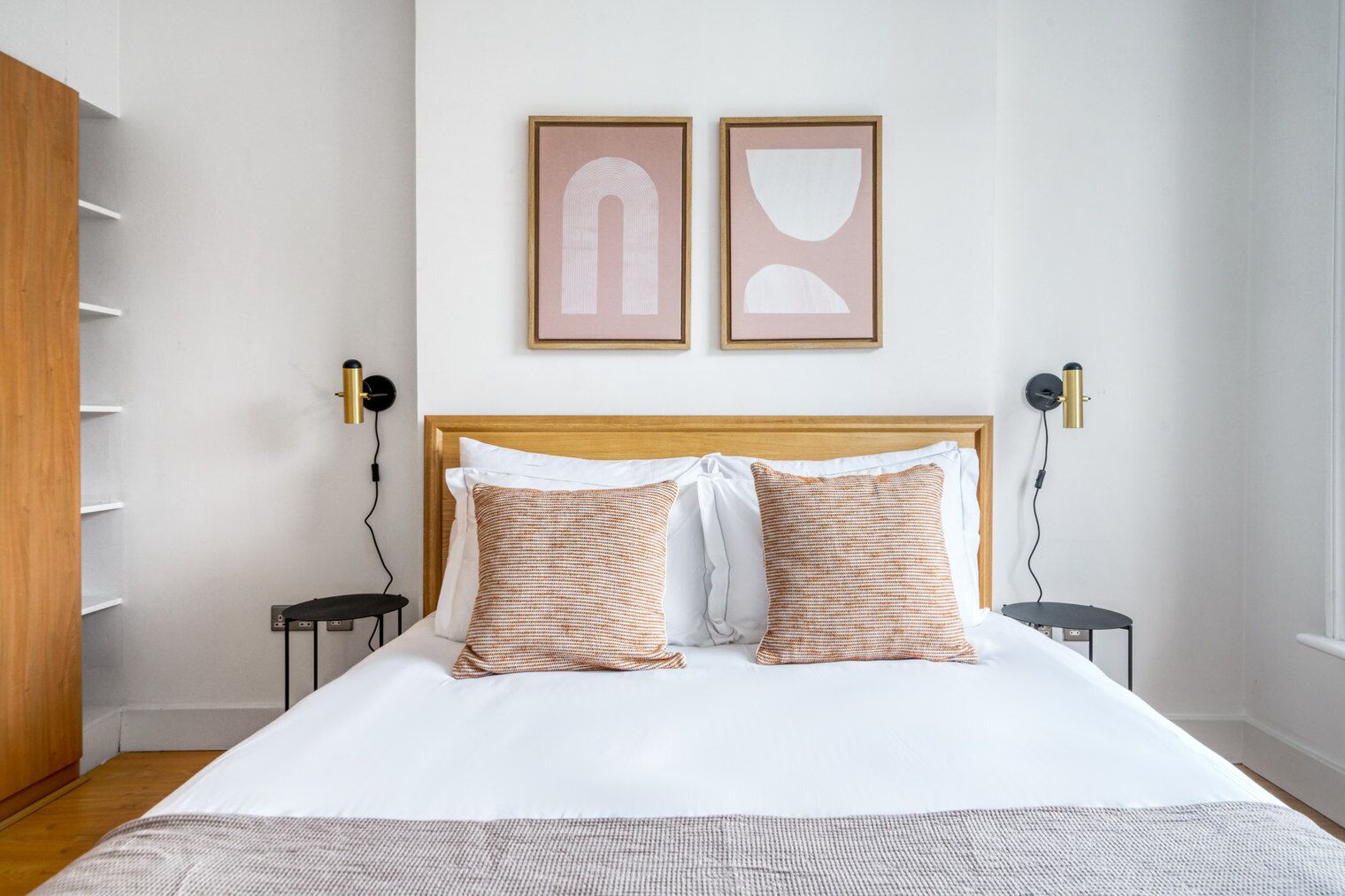 A neatly arranged bedroom with a large bed, two bedside tables, and a wardrobe.
