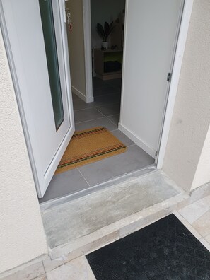 A doorway with a doormat and a black mat on the floor. - Le Paradis Iyedessil (Dijon)