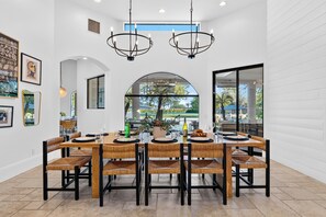 A dining area with a large table, chairs, and overhead lighting.