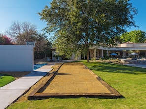 En baghave med swimmingpool, pergola og en patio.