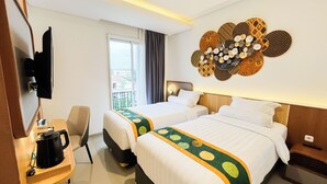 A hotel room with two beds, a TV, a coffee maker, and a decorative wall piece. - Front One The Andia Boyolali (Boyolali)