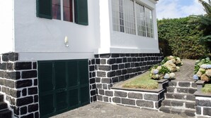 A white building with green shutters, stone steps, and a garden with hydrangeas. - Family Holiday Villa Vacation Ponta Delgada (POnta Delgada)