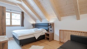 A bedroom with a bed, bedside tables, a nightstand, a radiator, a window, and a view of the outdoors. - Luxury chalet with private sauna (Donnersbachwald)