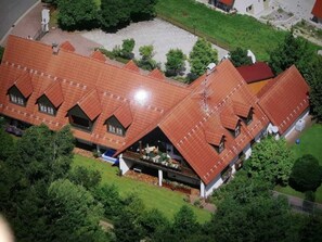 Un grand bâtiment doté de plusieurs sections de toit et d’une cour intérieure.