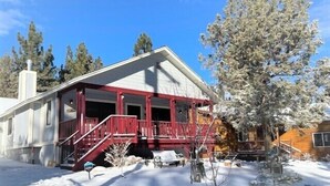 A two-story house with a red porch and a chimney. - Moose Tracks Lodge - Game Room, Ping Pong, Shuffleboard, Barbecue (Big Bear City)