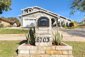 Una casa con un buzón de piedra que tiene el número 6703.